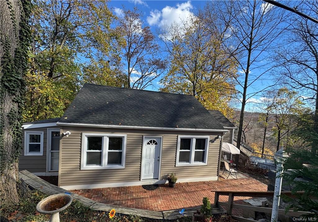 a front view of house with yard and trees in the background