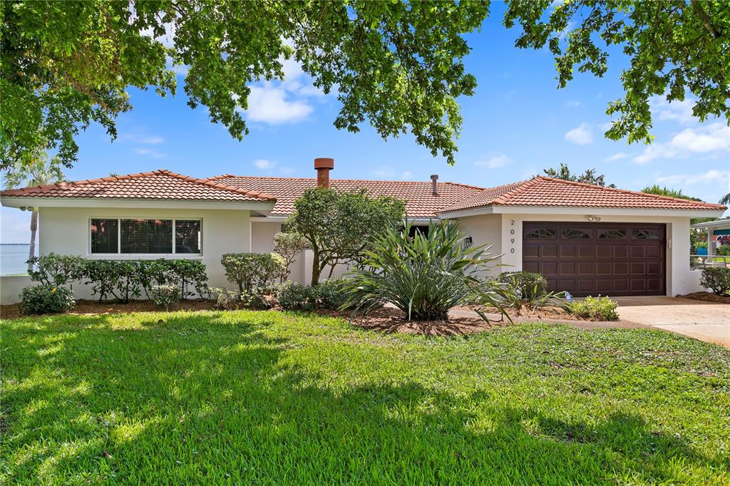 a front view of a house with a garden and yard