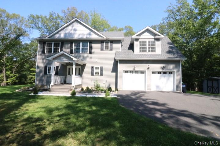 a front view of a house with a yard and trees