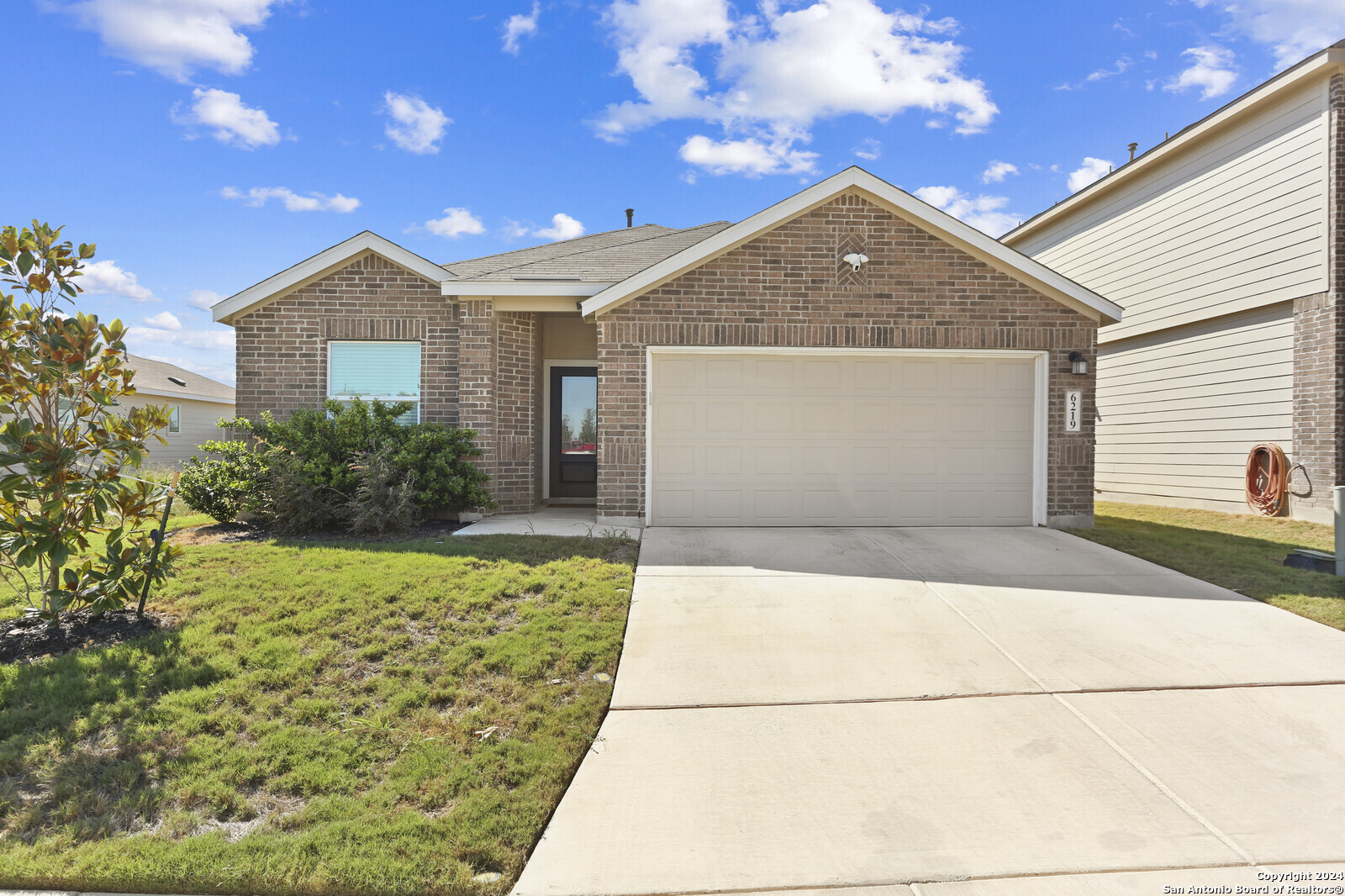 a front view of a house with a yard and garage