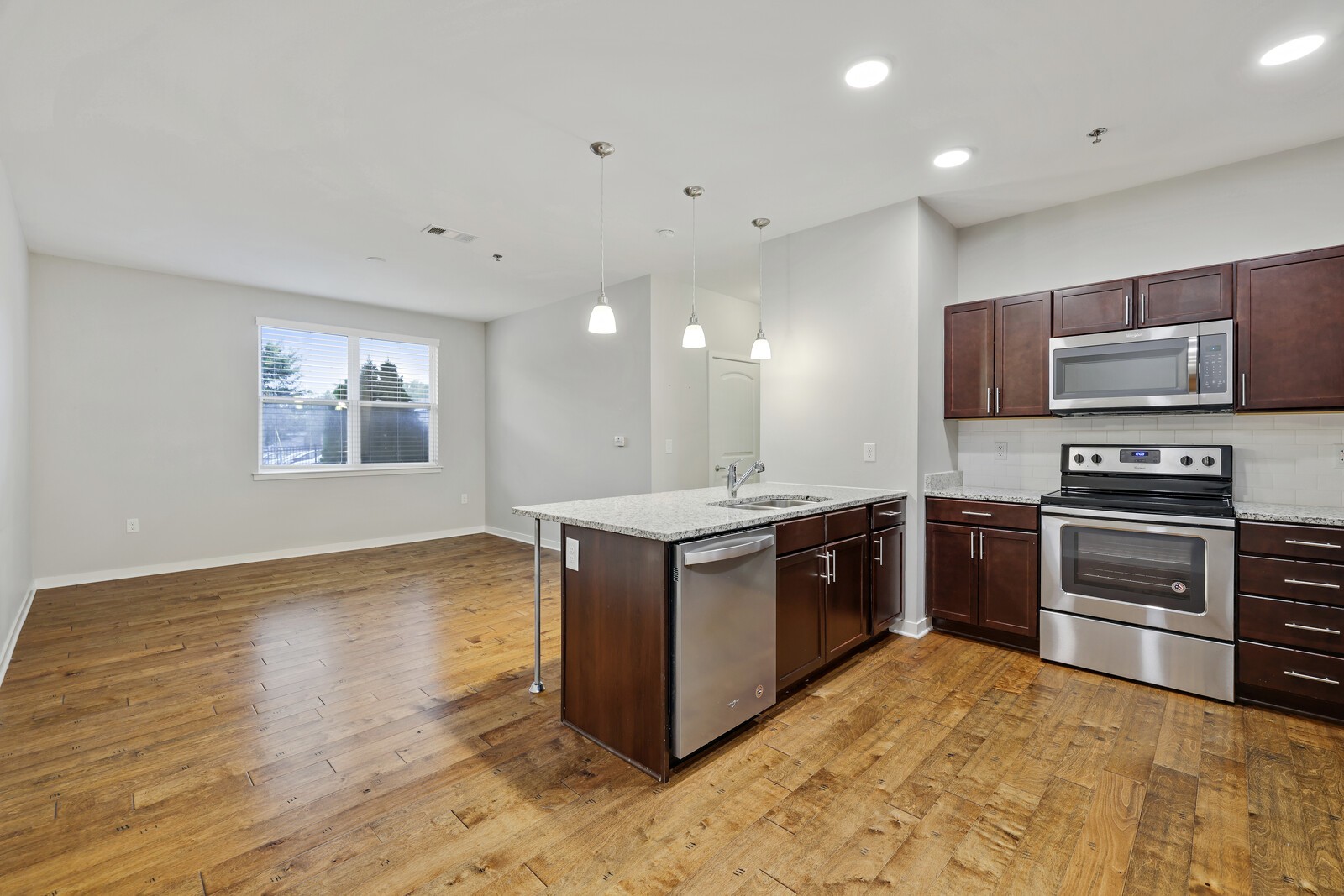 a kitchen with stainless steel appliances granite countertop a stove a sink and a refrigerator