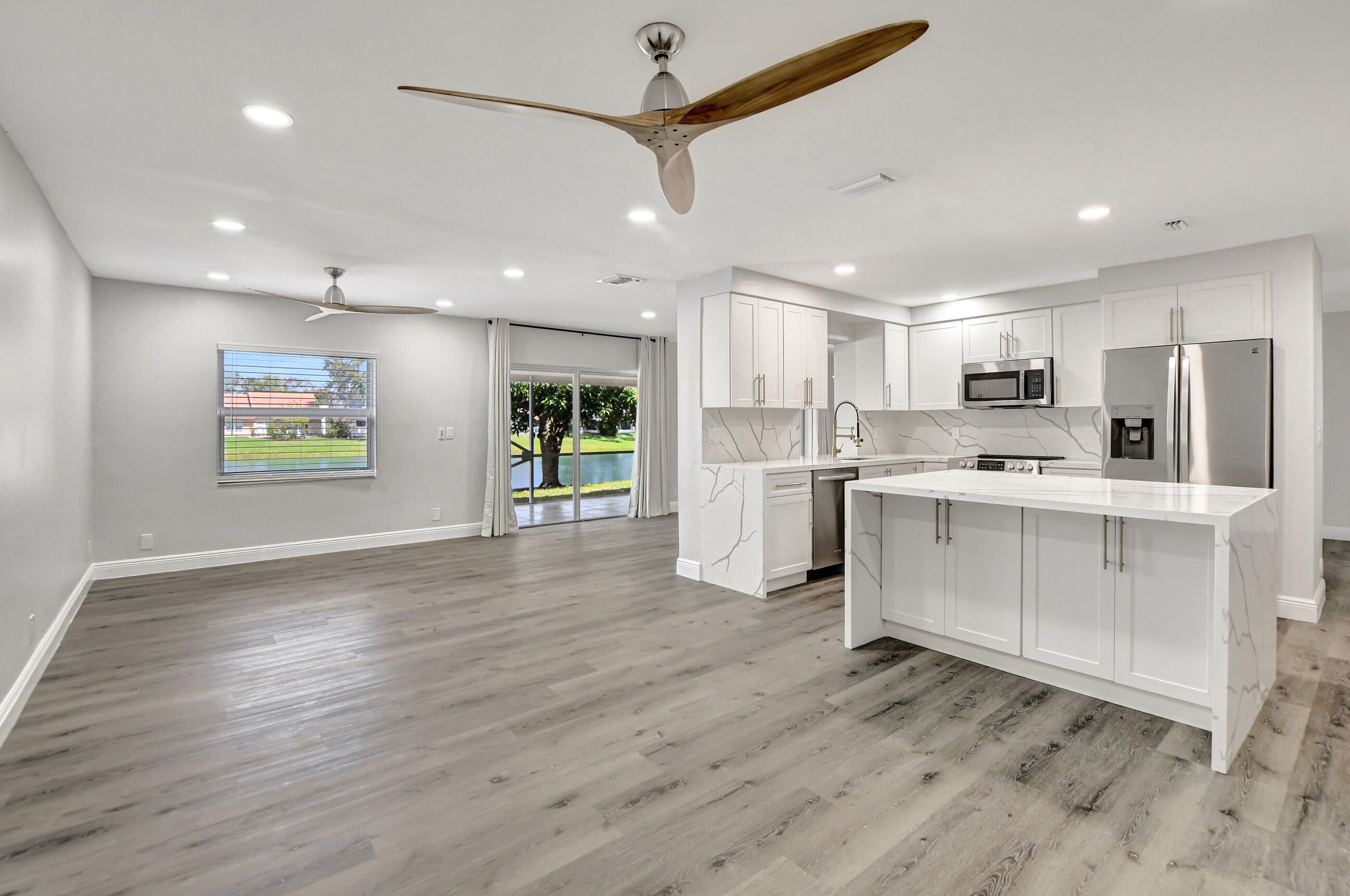 a kitchen with stainless steel appliances kitchen island wooden cabinets and wooden floor