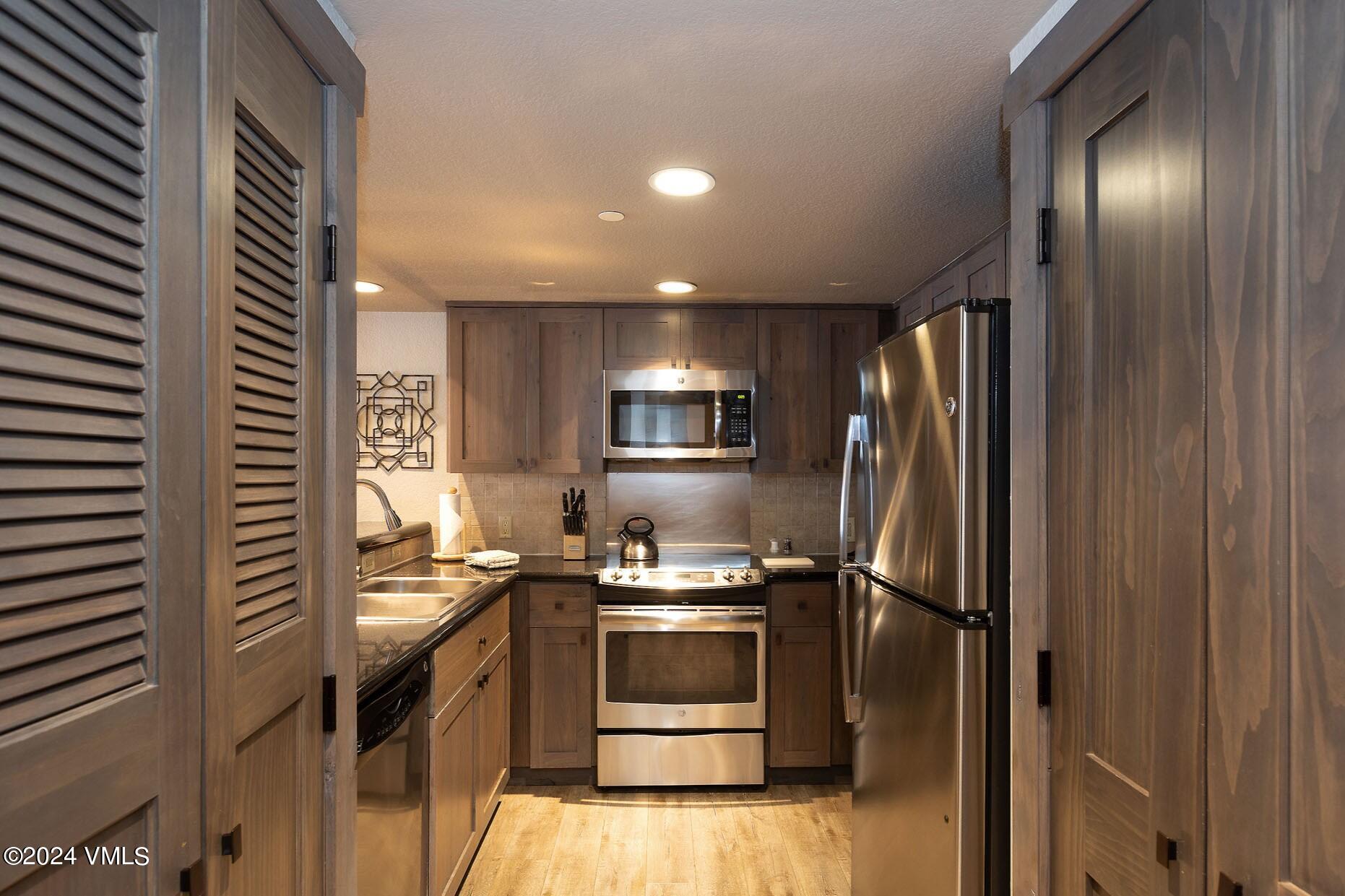 a kitchen with a refrigerator and a stove