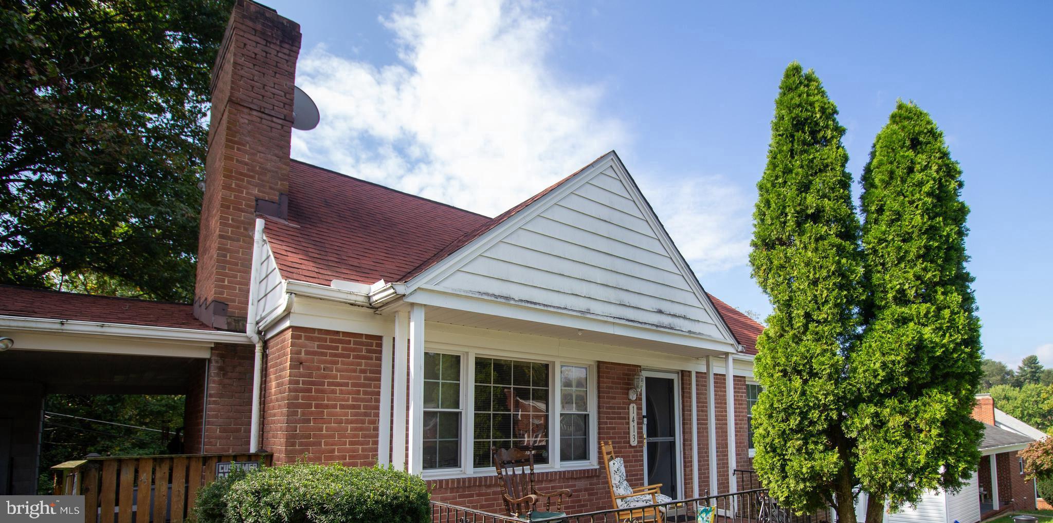 a view of a house with potted plants and a tree