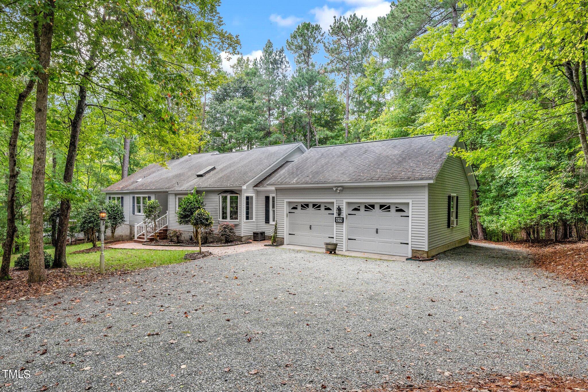 a view of a house with large trees and a small yard