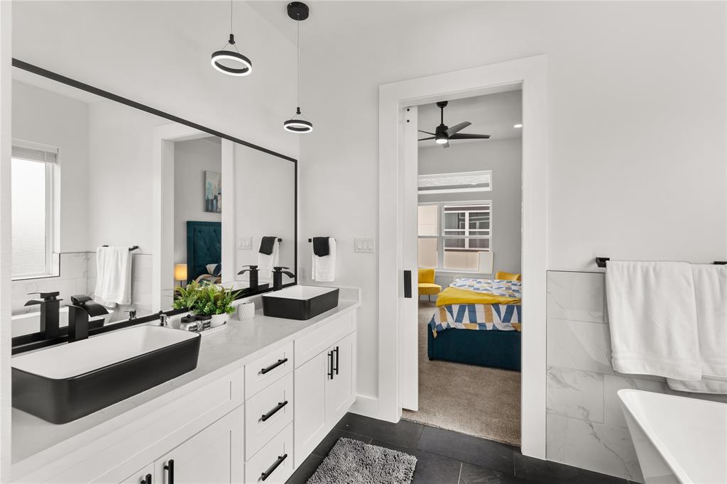 a spacious en suite bathroom with a double vanity sink and a mirror