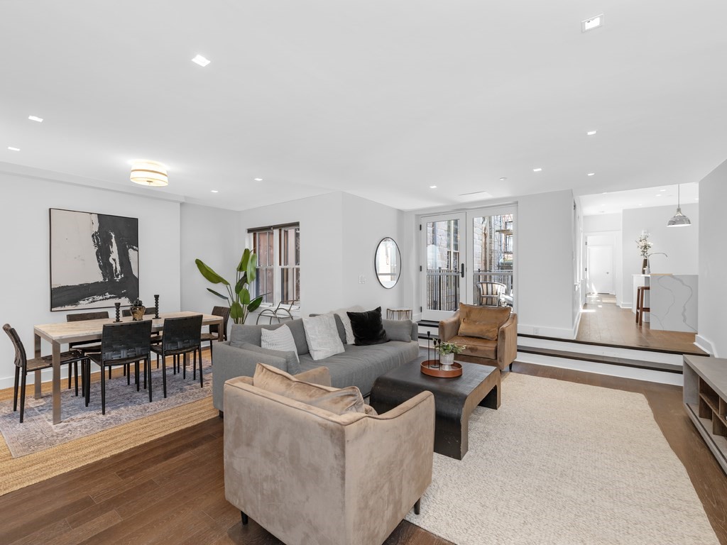 a living room with furniture wooden floor and a large window