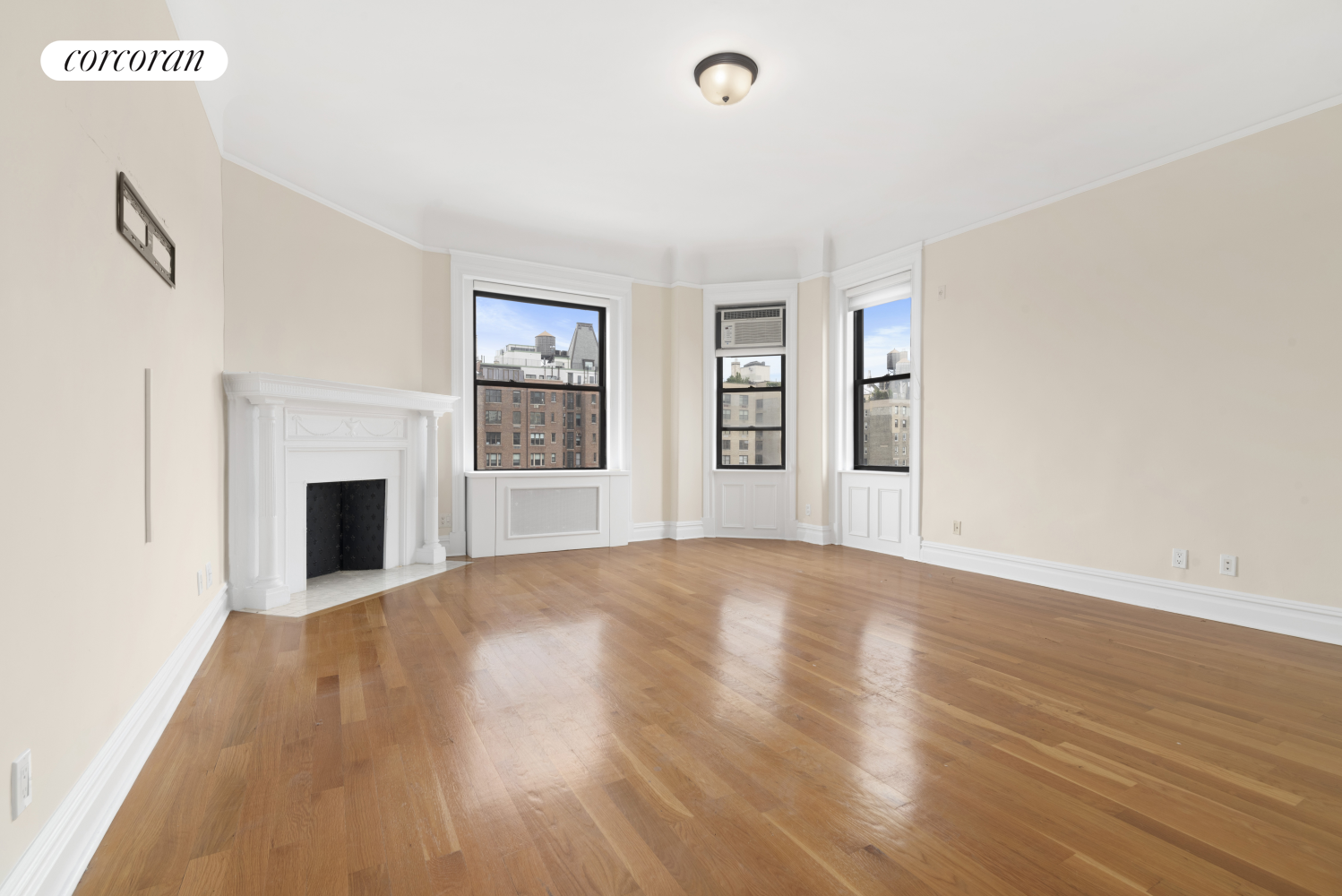 wooden floor fireplace and windows in an empty room