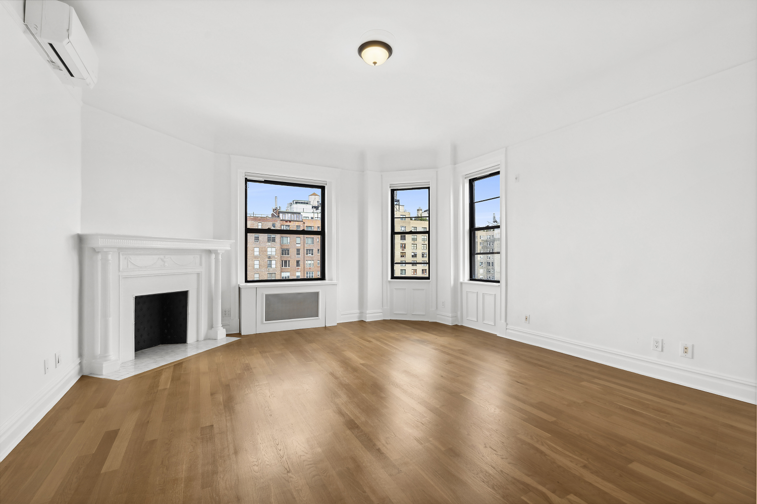 an empty room with windows and fireplace