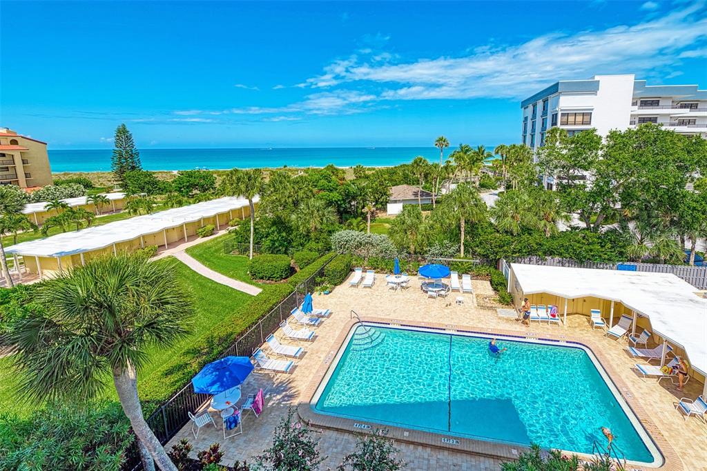 a view of a swimming pool with a patio and a yard