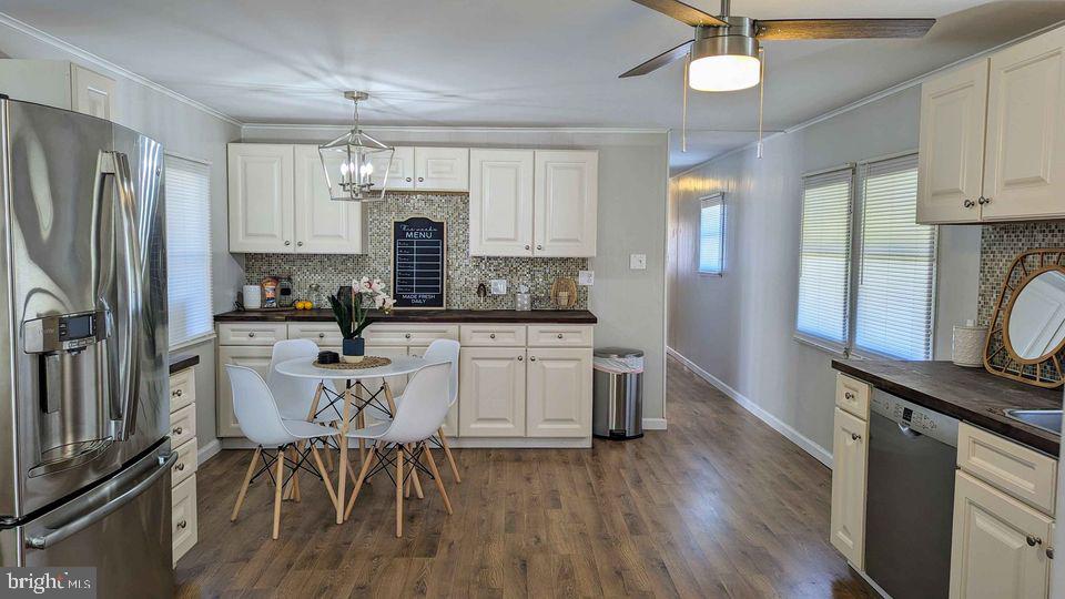 a kitchen with a table chairs refrigerator and cabinets