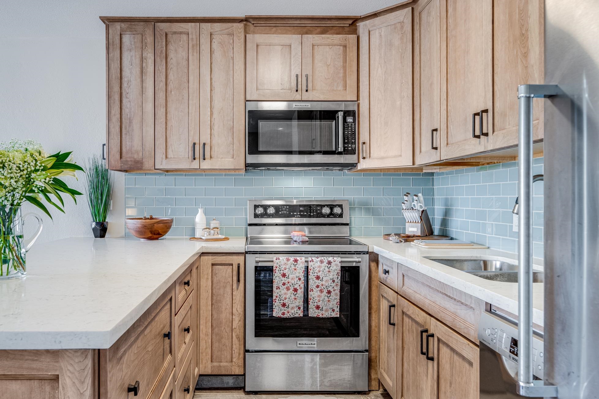 a kitchen with granite countertop white cabinets and stainless steel appliances