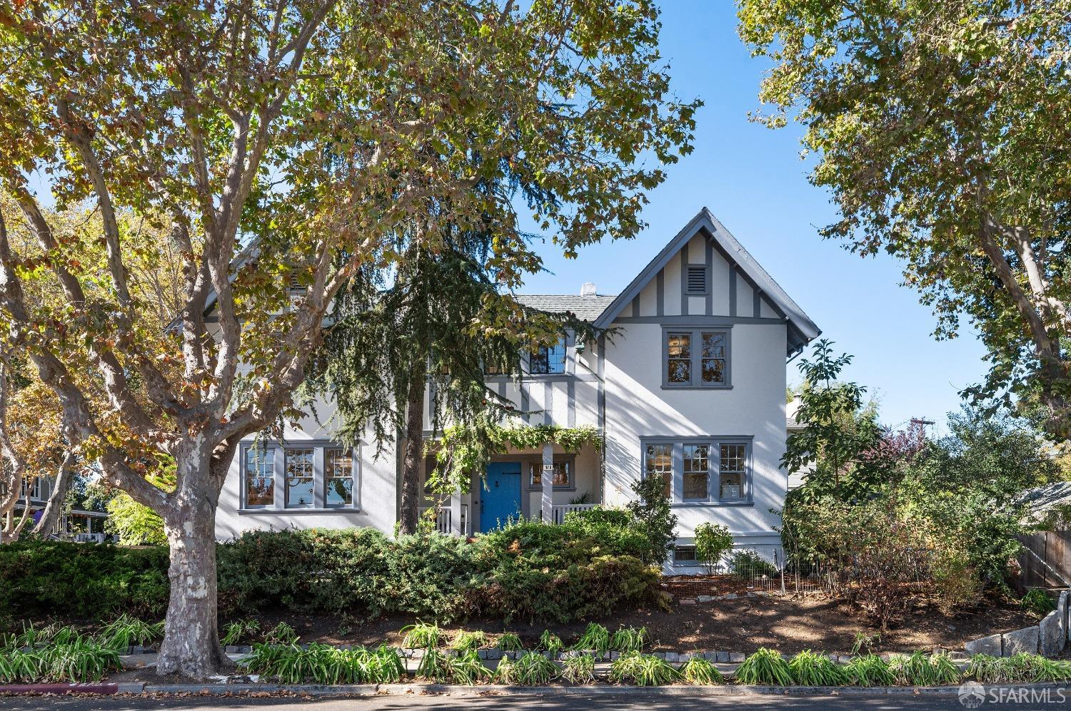 a front view of a house with a yard and potted plants