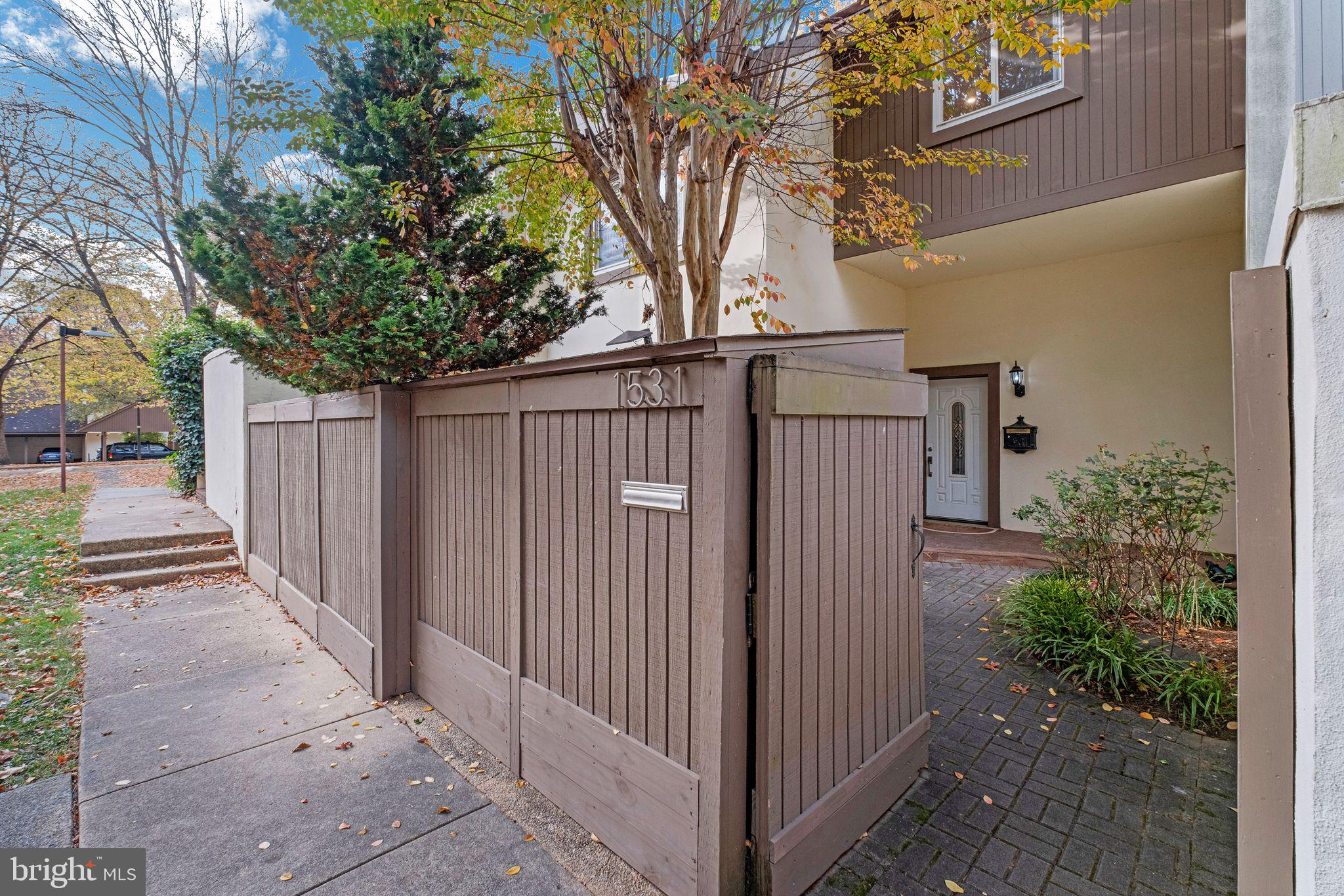 a view of a pathway of a house with wooden fence