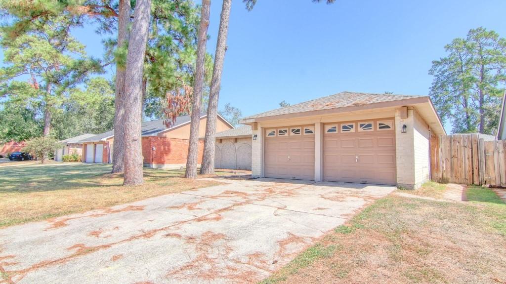 a view of a house with a yard and large tree