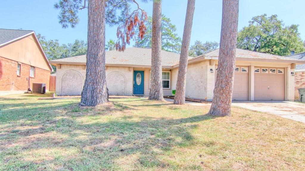 a view of a house with a backyard and a tree