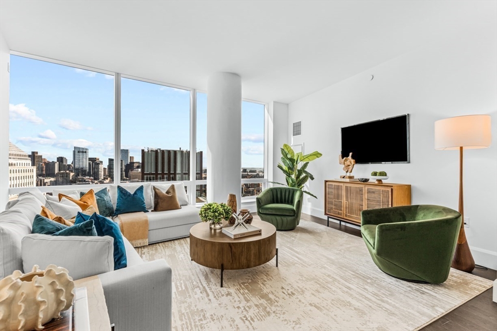 a living room with furniture potted plant and a flat screen tv