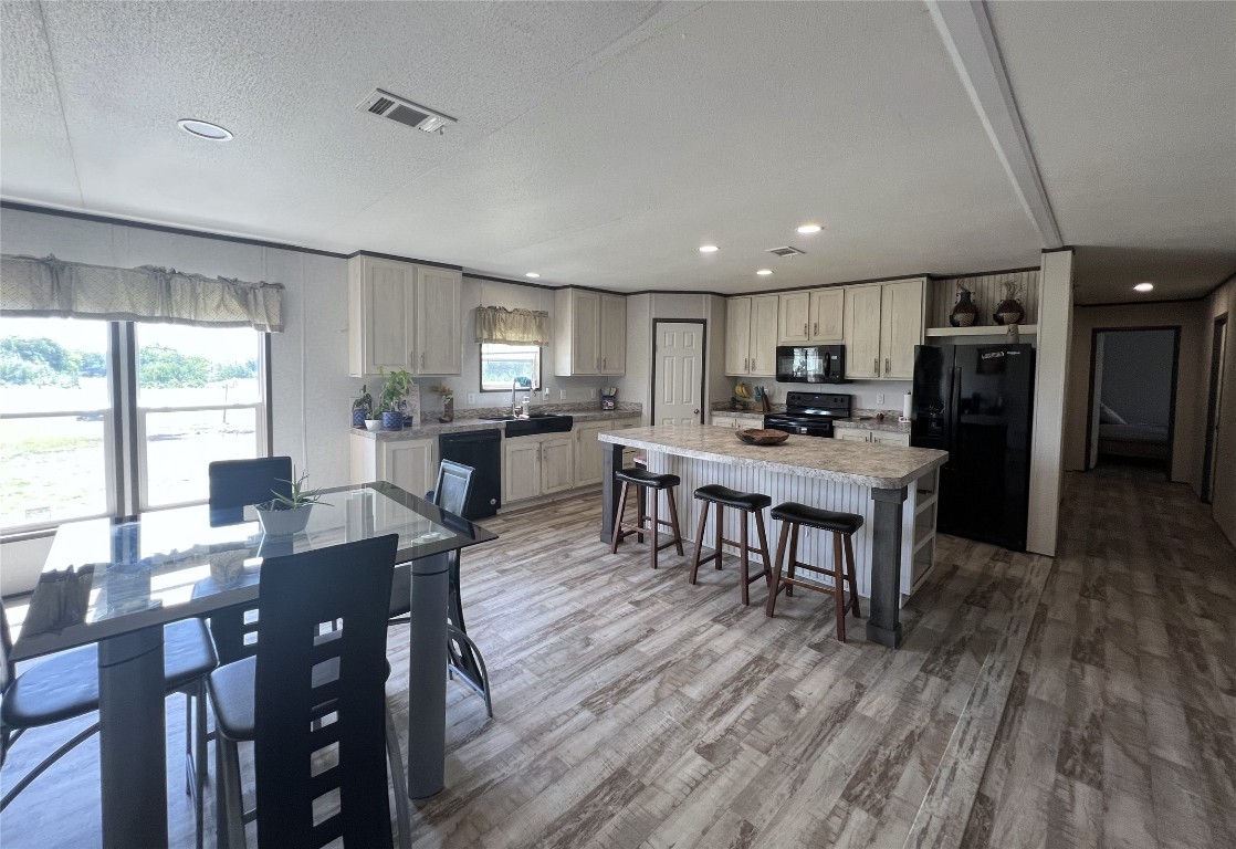 a living room with stainless steel appliances kitchen island granite countertop furniture wooden floor and a view of kitchen