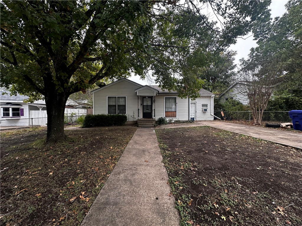 a front view of a house with a yard and large trees