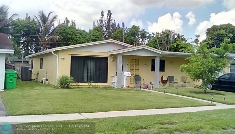 a front view of a house with a yard and trees