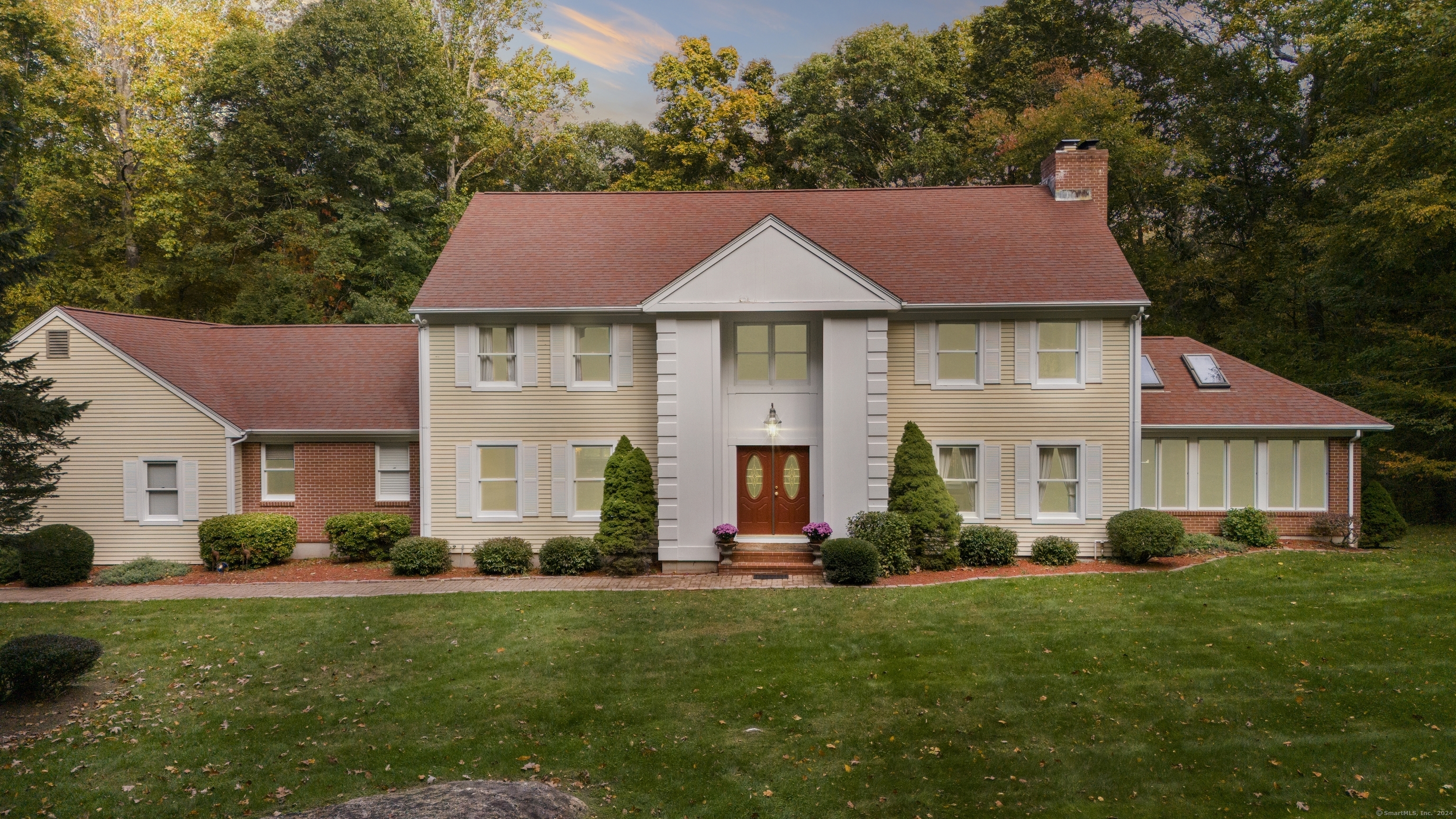 a front view of a house with a yard and green space