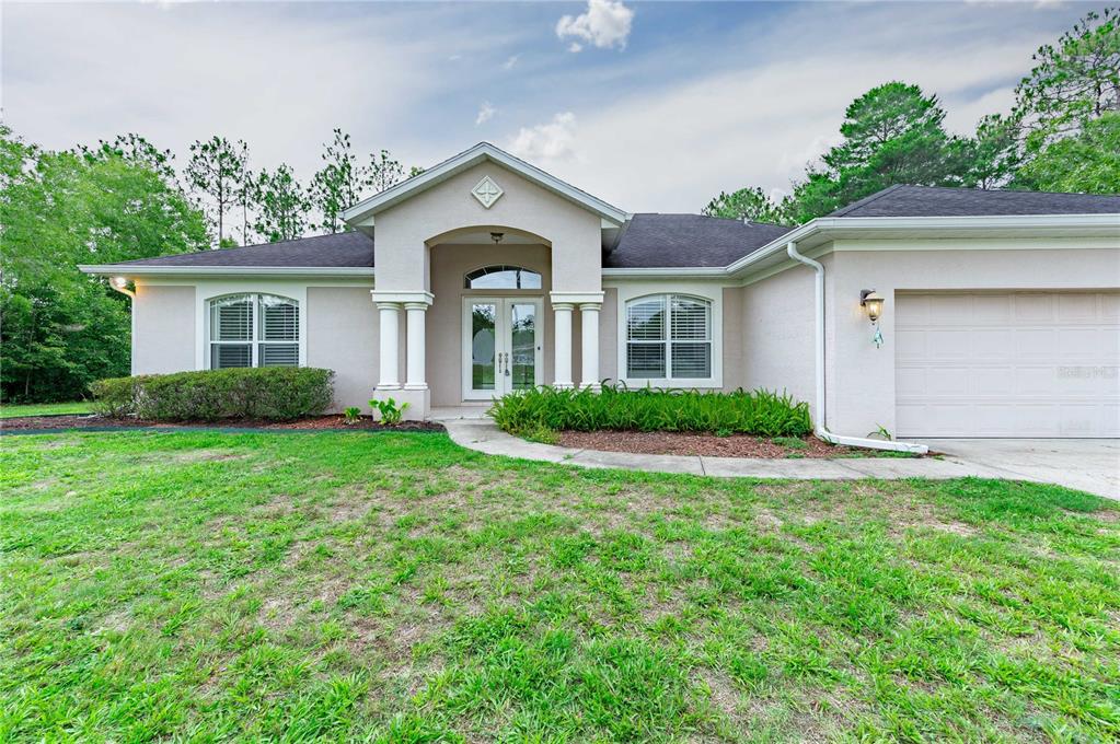 a front view of a house with a yard and garage