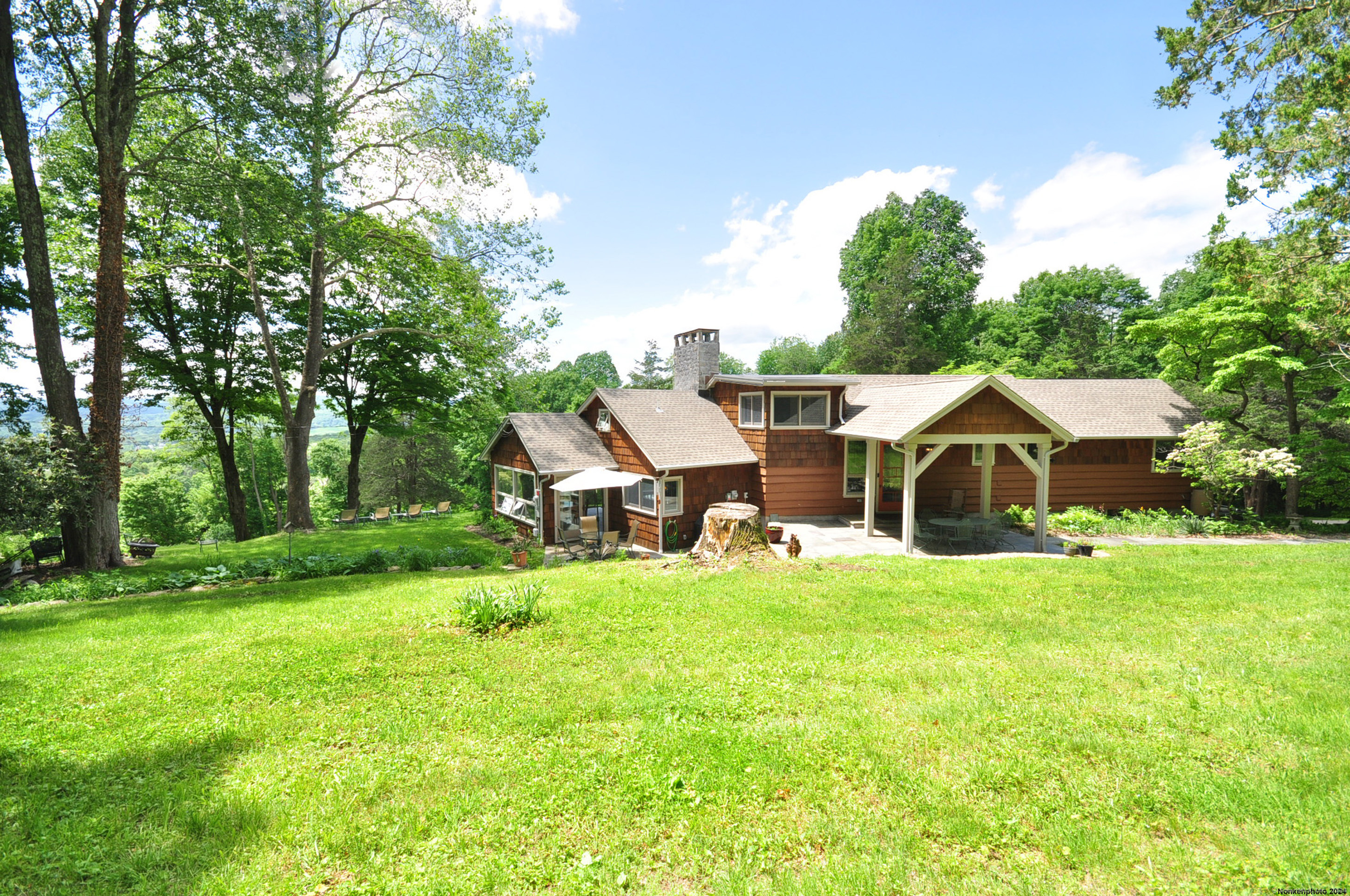 a front view of a house with a yard and trees