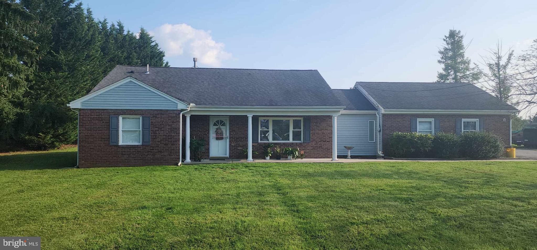 a front view of a house with a yard and trees