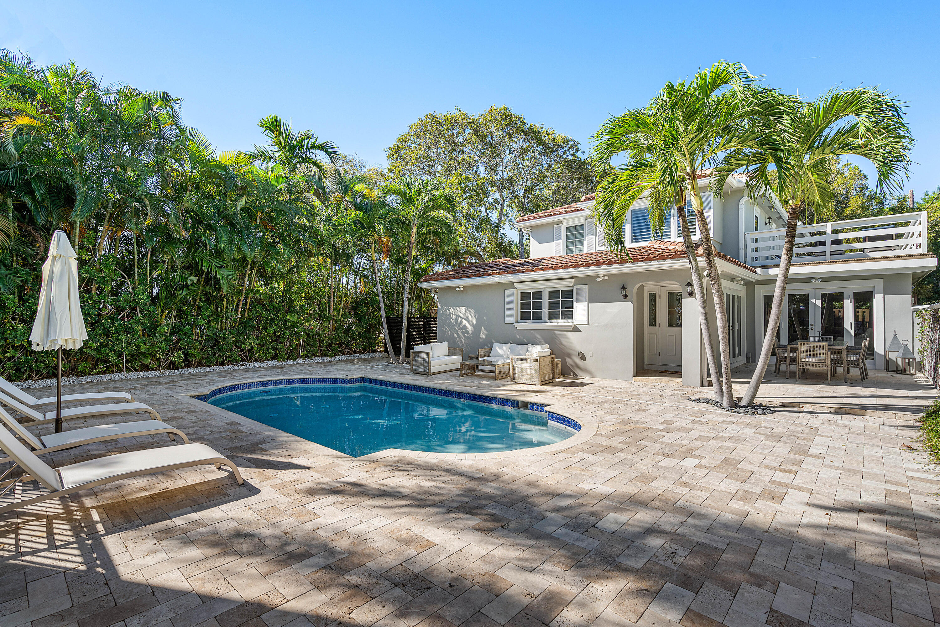 a view of a house with pool and sitting area