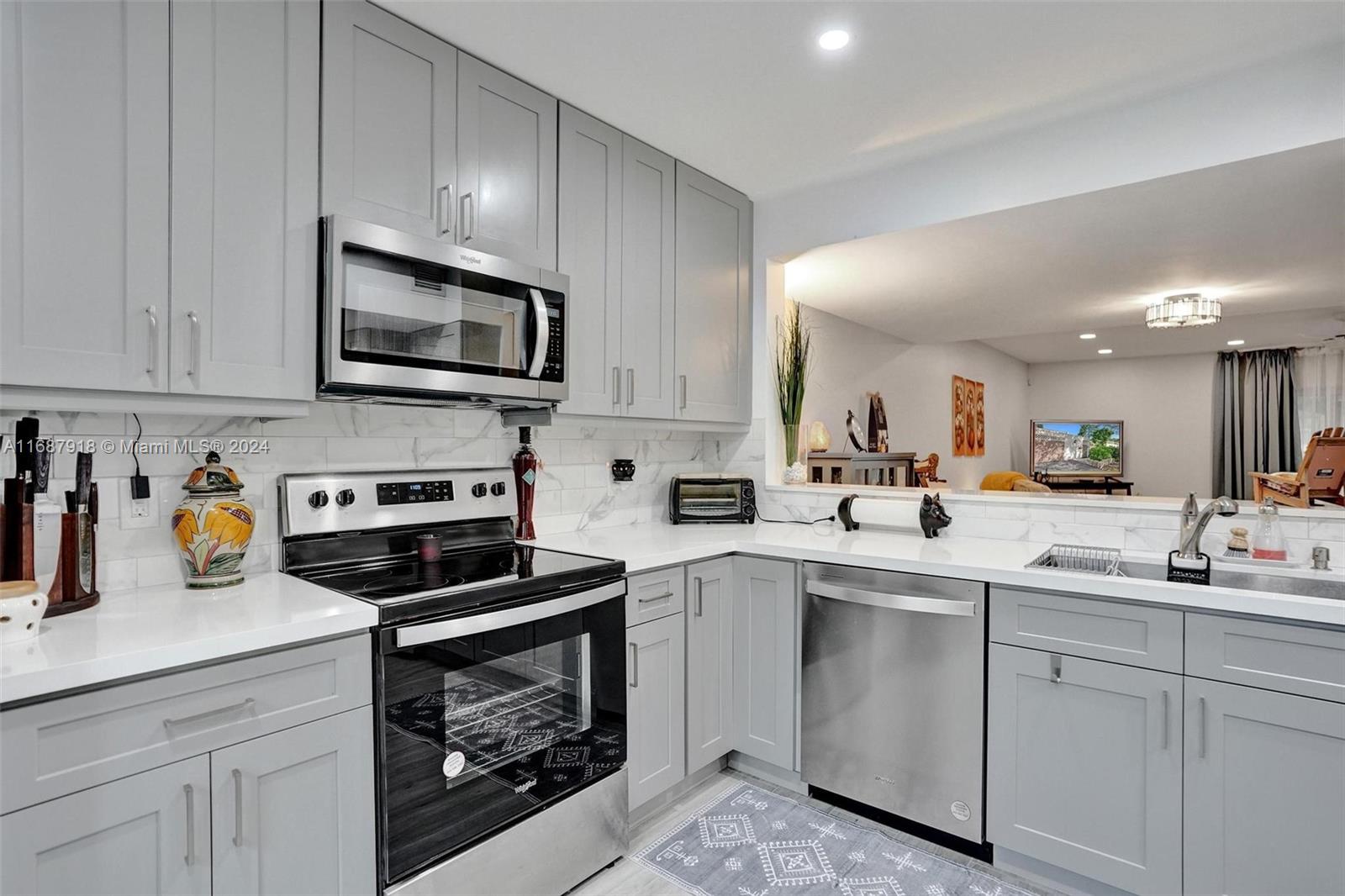 a kitchen with sink a microwave and cabinets