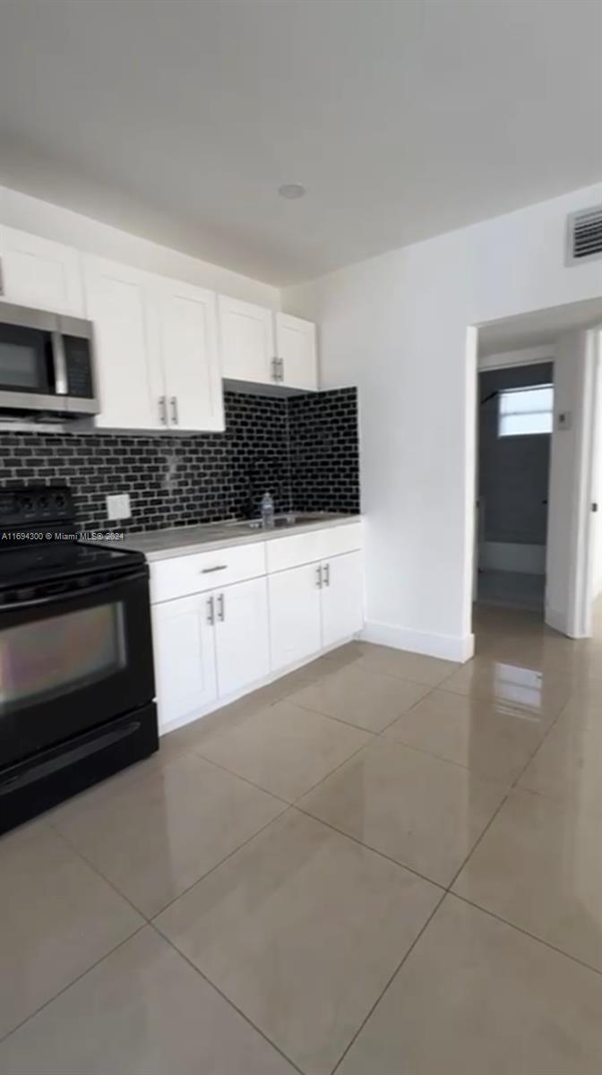 a kitchen with granite countertop a stove and a sink