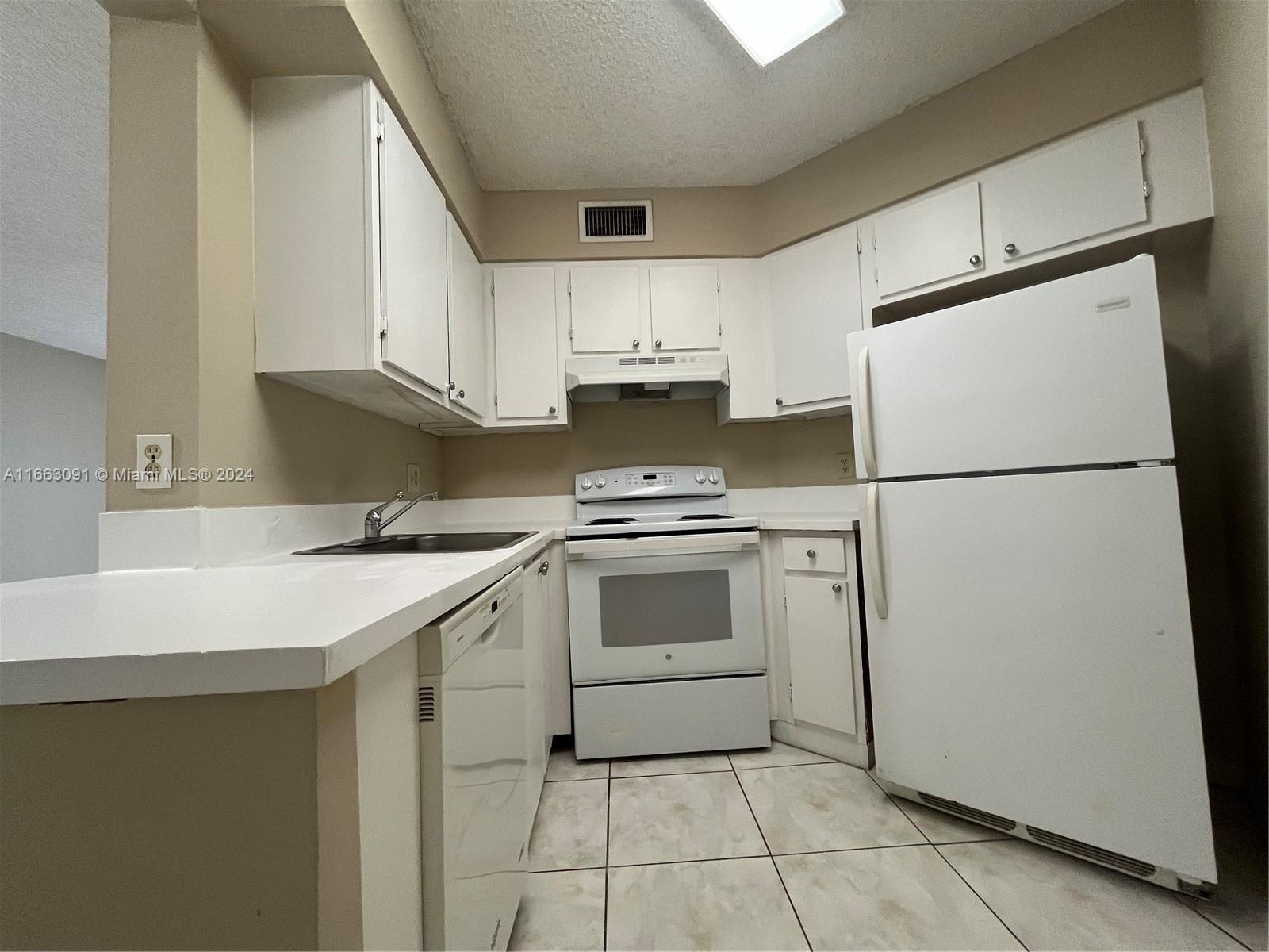 a kitchen with a refrigerator sink stove and cabinets