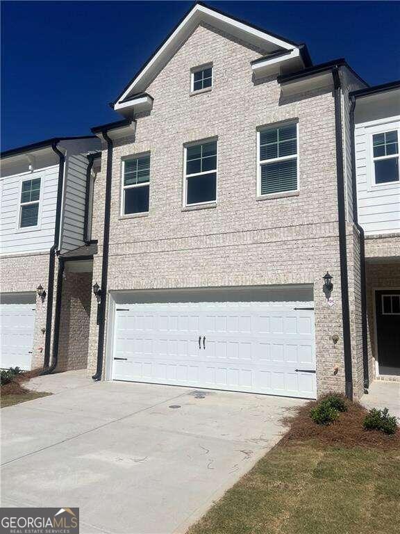 a front view of a house with a parking space