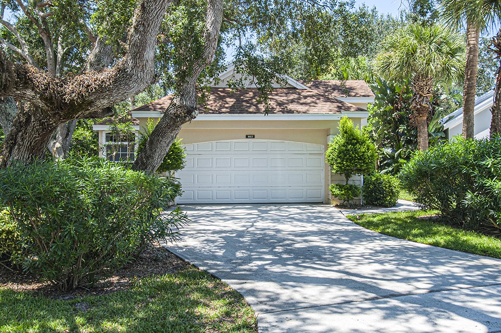 a view of a house with a yard and large tree