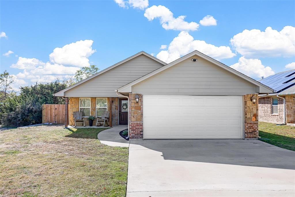 View of front of home with a front yard and a garage