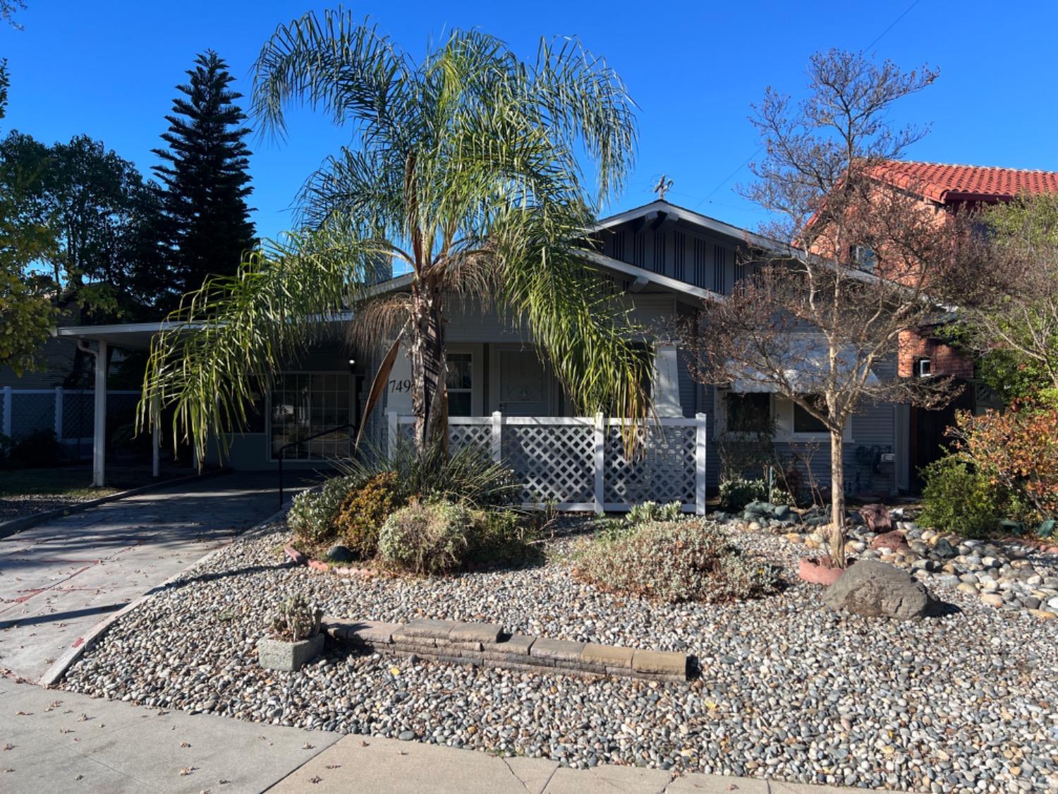 a view of a house with a small yard and potted plants