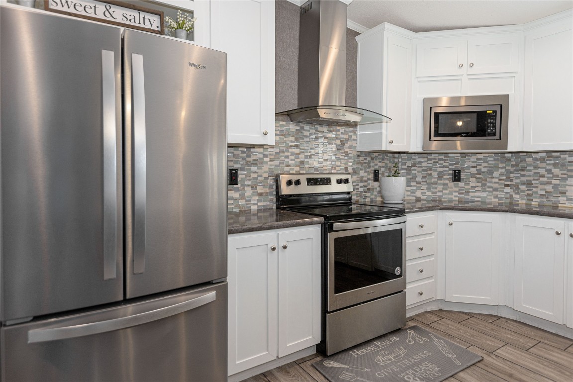 a kitchen with stainless steel appliances white cabinets and a granite counter top
