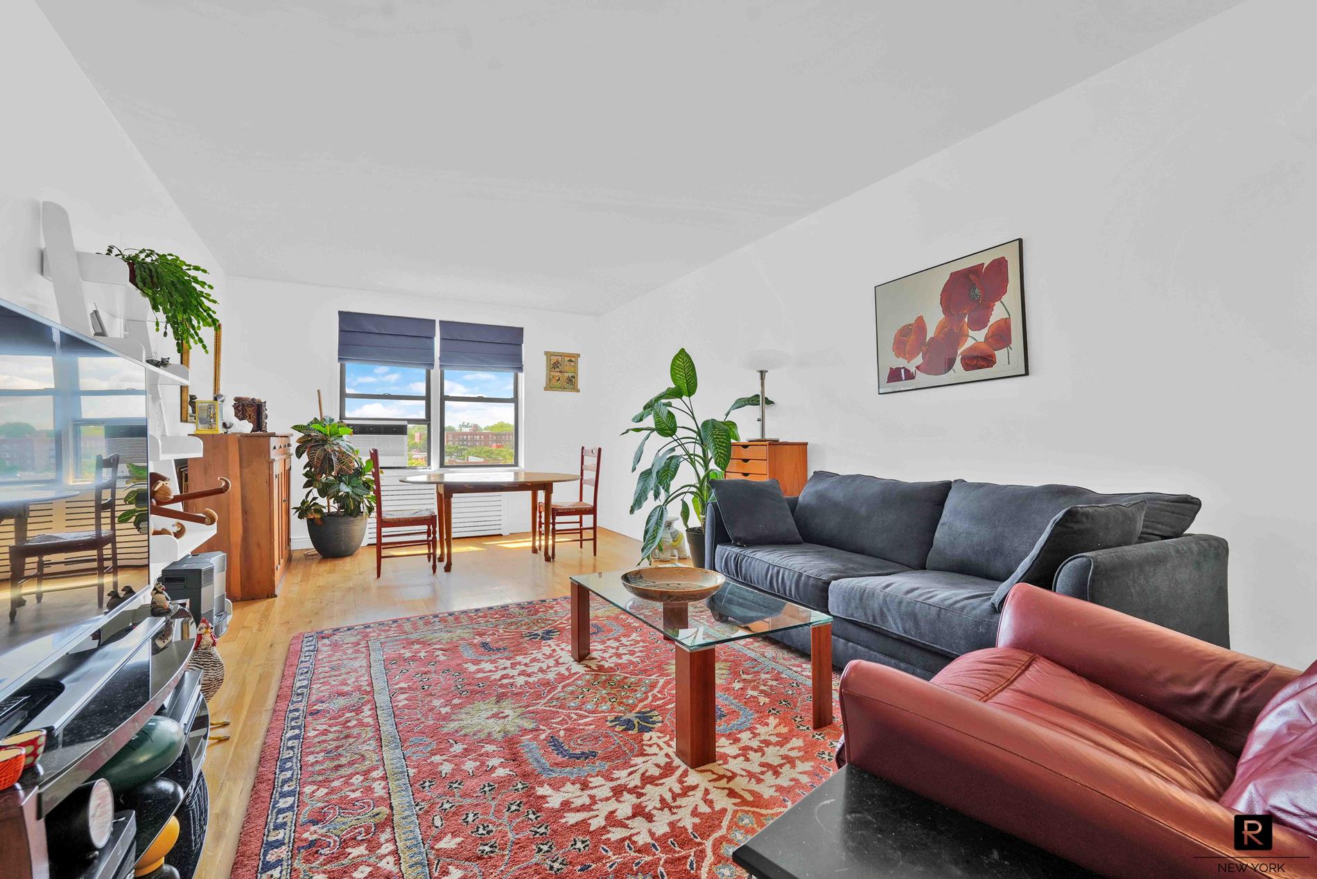 a living room with furniture a rug and a bookshelf