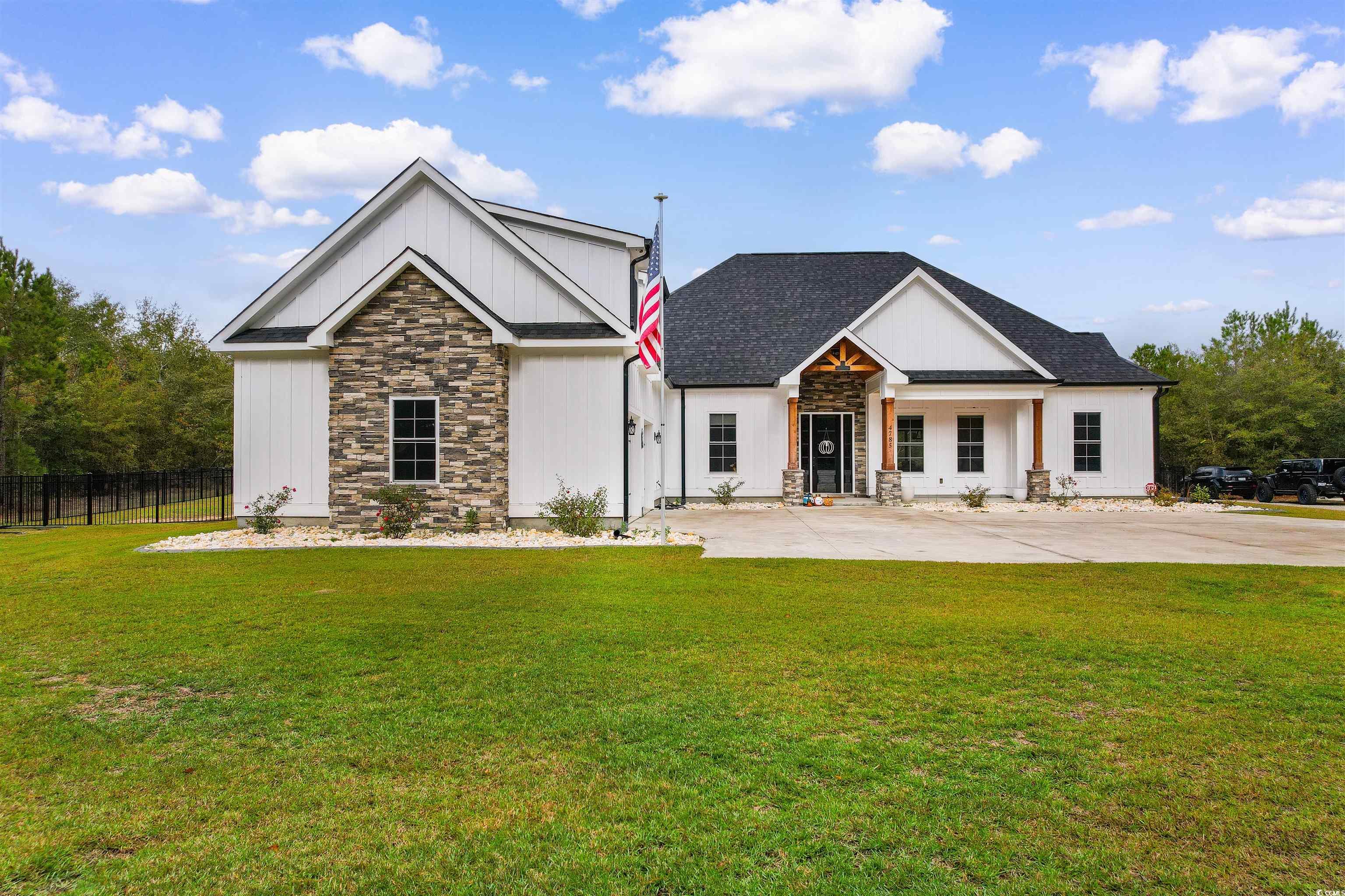 Modern inspired farmhouse featuring a front yard a