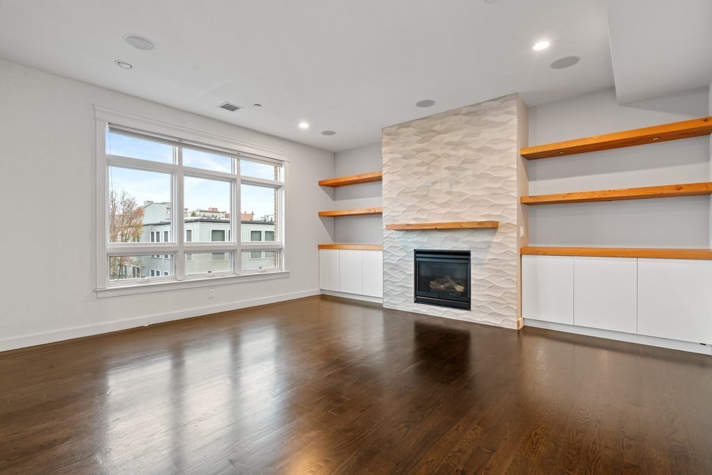 an empty room with floor to ceiling windows and fireplace