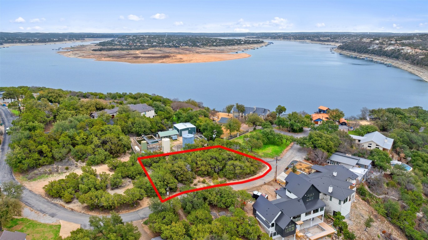 an aerial view of ocean and residential houses with outdoor space