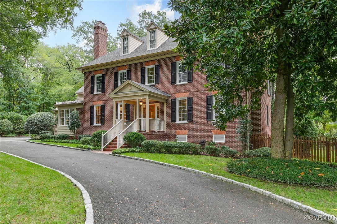 a front view of a house with a yard and trees