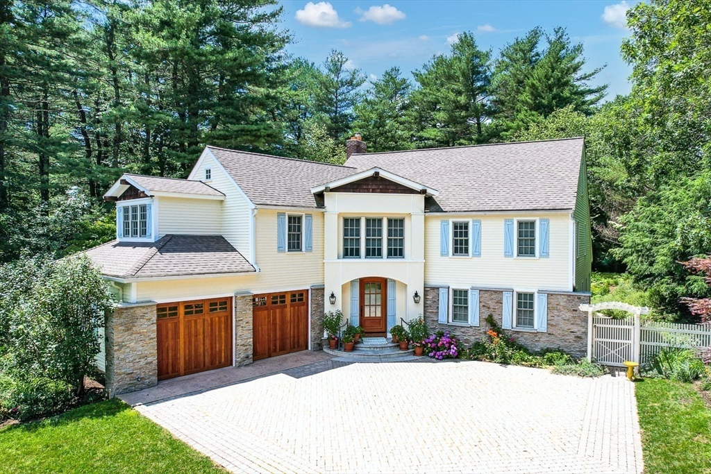 a front view of a house with a garden and trees