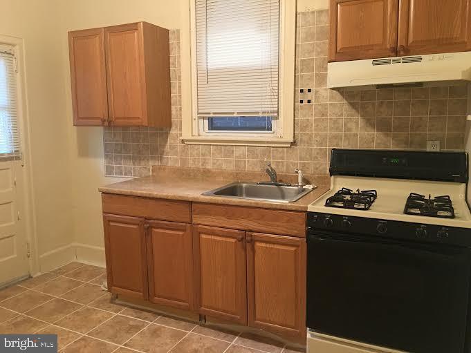 a kitchen with stainless steel appliances a sink stove and cabinets