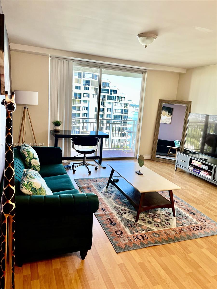 a living room with couch guitar and a flat screen tv