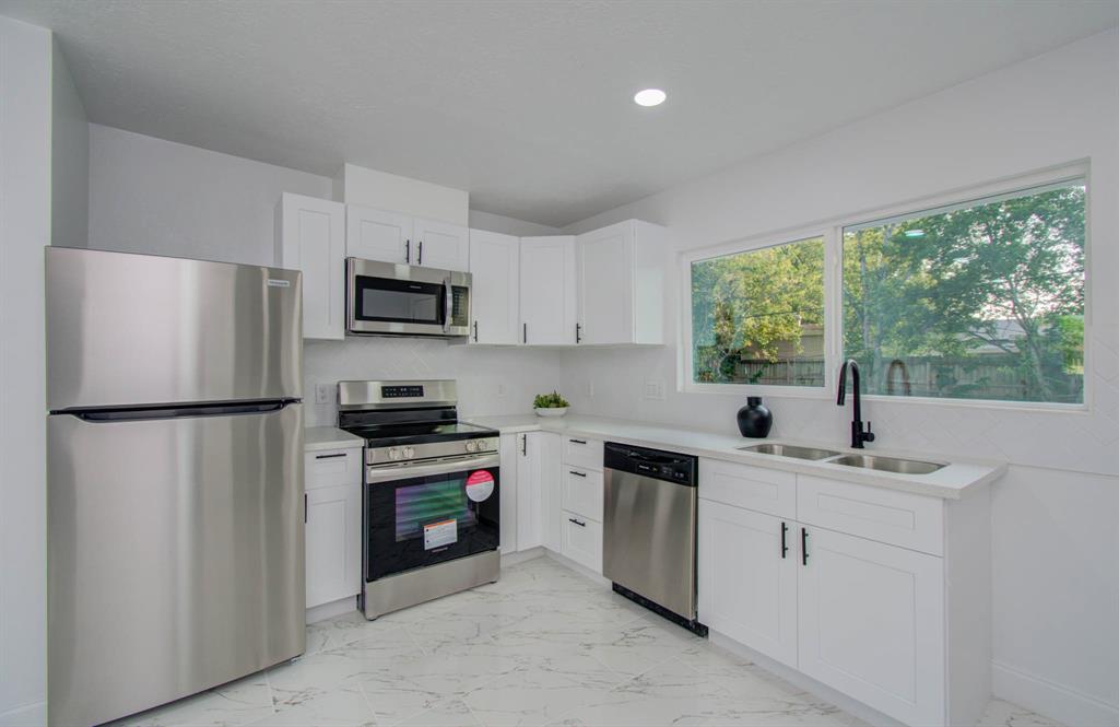 a kitchen with white cabinets and stainless steel appliances