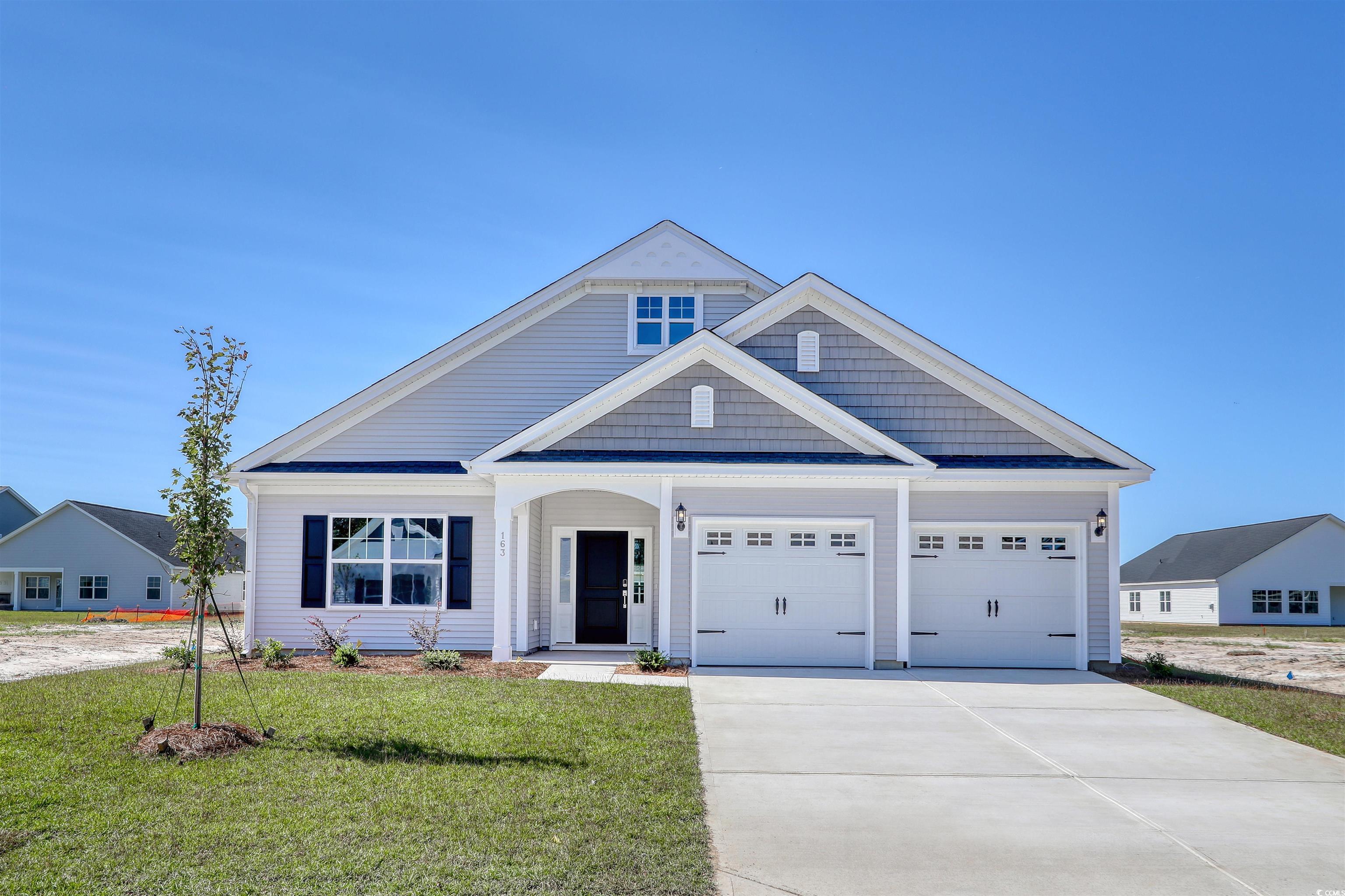 View of front of home with a garage and a front la