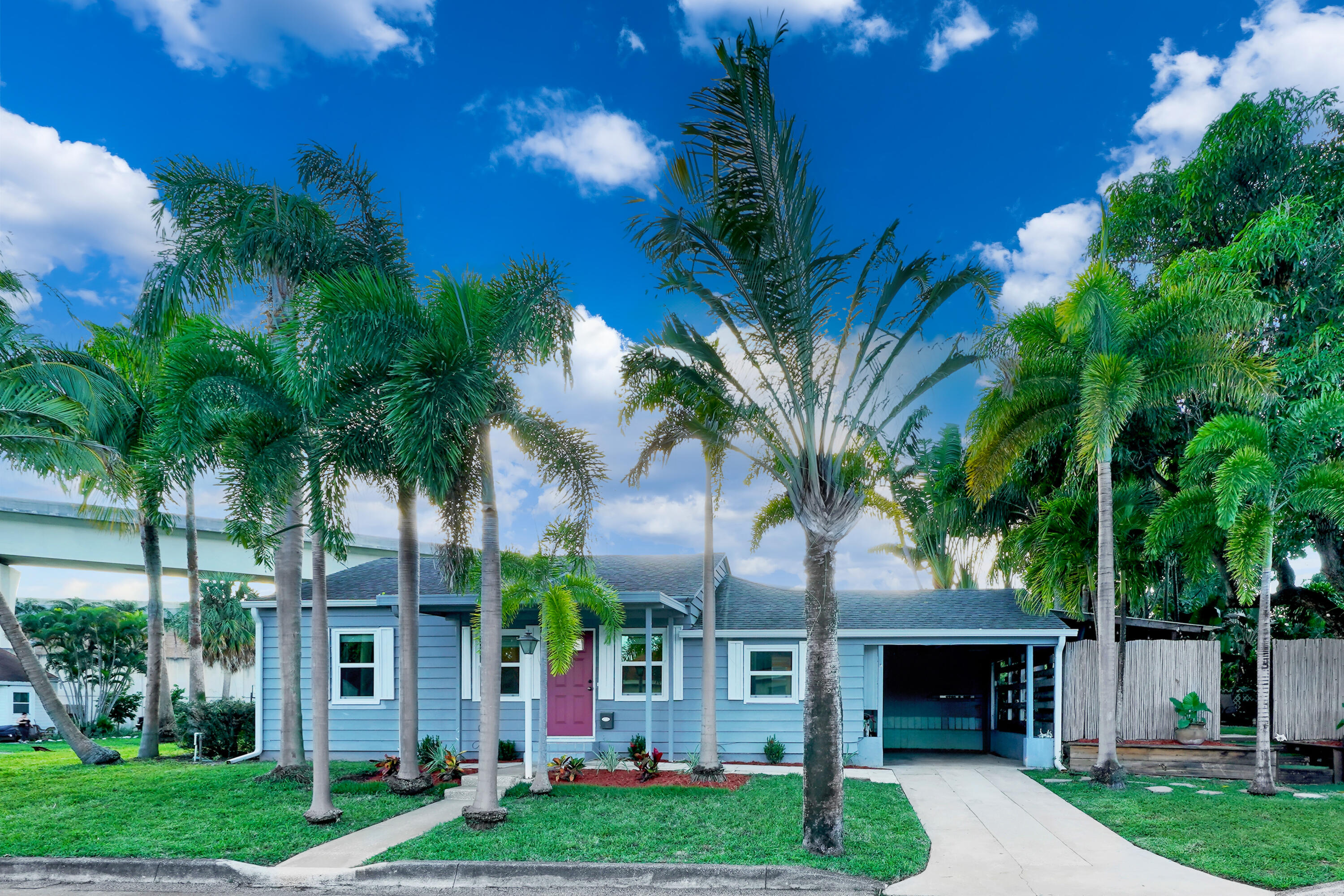 a front view of a house with garden and trees