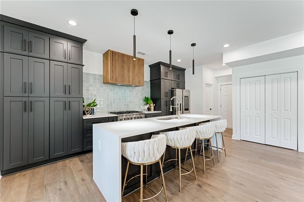 a kitchen with stainless steel appliances granite countertop a table chairs stove and wooden floor