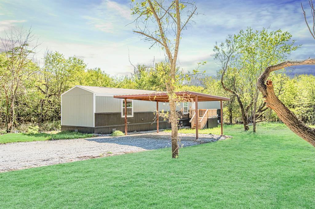 a view of a house with a backyard and a tree